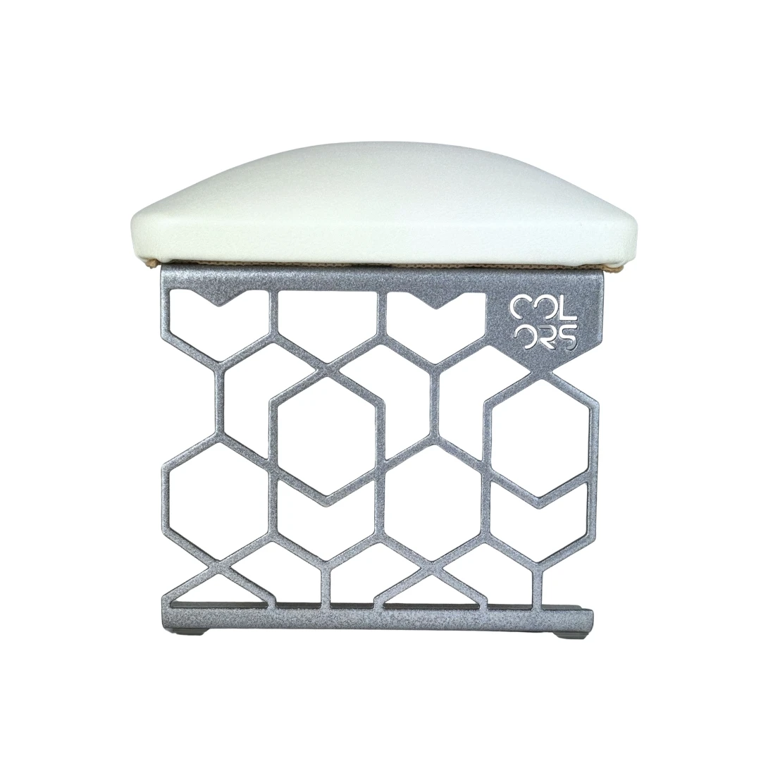 Stylowa podpórka do manicure w kolorze srebrnym, wykonana z metalu, ustawiona na stole kosmetycznym